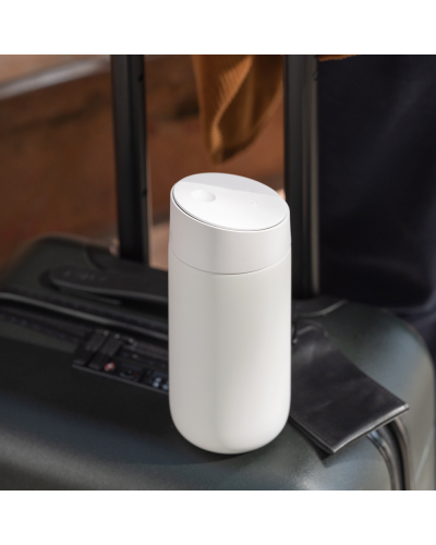 Fellow Carter Slide Mug 12oz Matte White on a suitcase