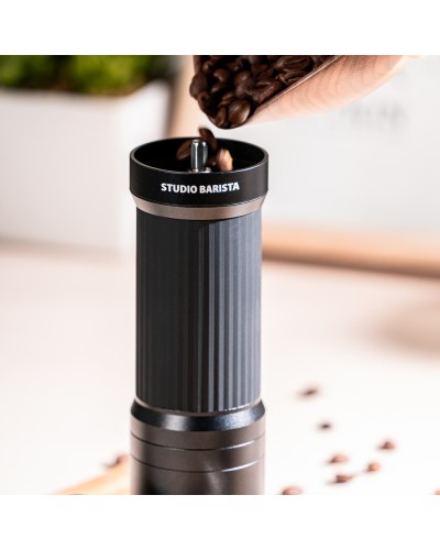 Pouring coffee beans into Manual Coffee Grinder with Foldable Handle Black